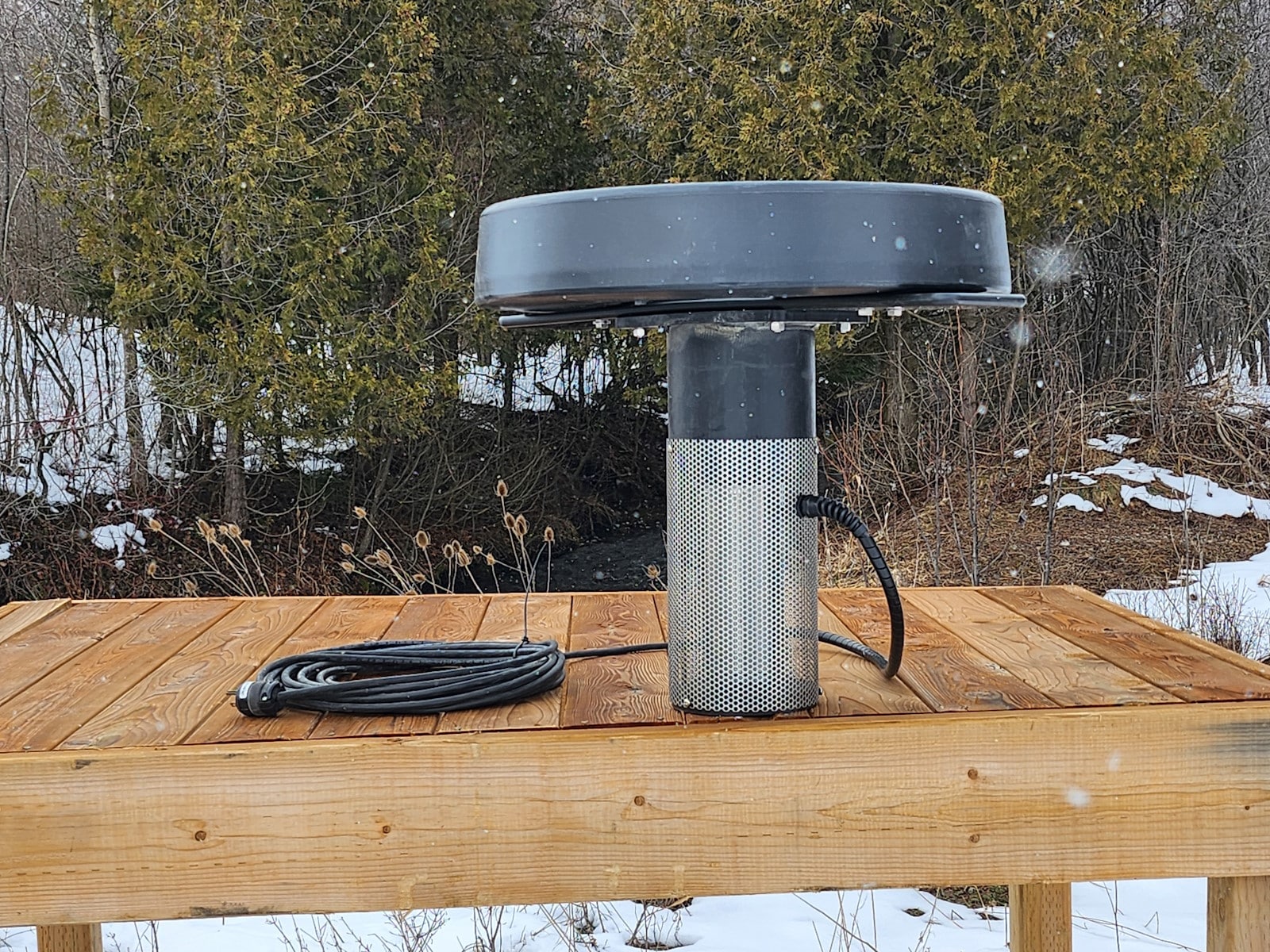 Olympus Fountain Half HP - Pond Perfections Olympus Fountain Half HP unit displayed on a wooden surface outdoors.